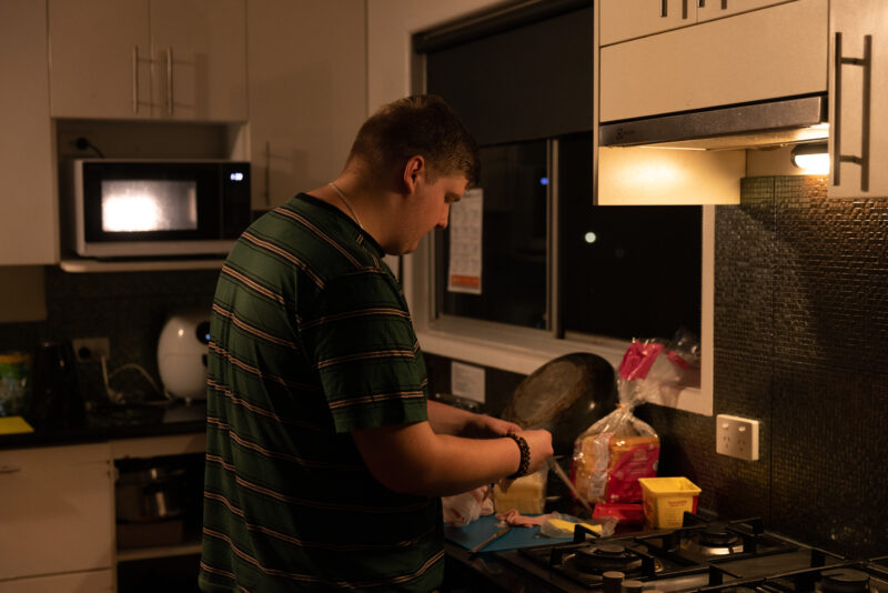 Independent young person in placement and transition support making dinner.