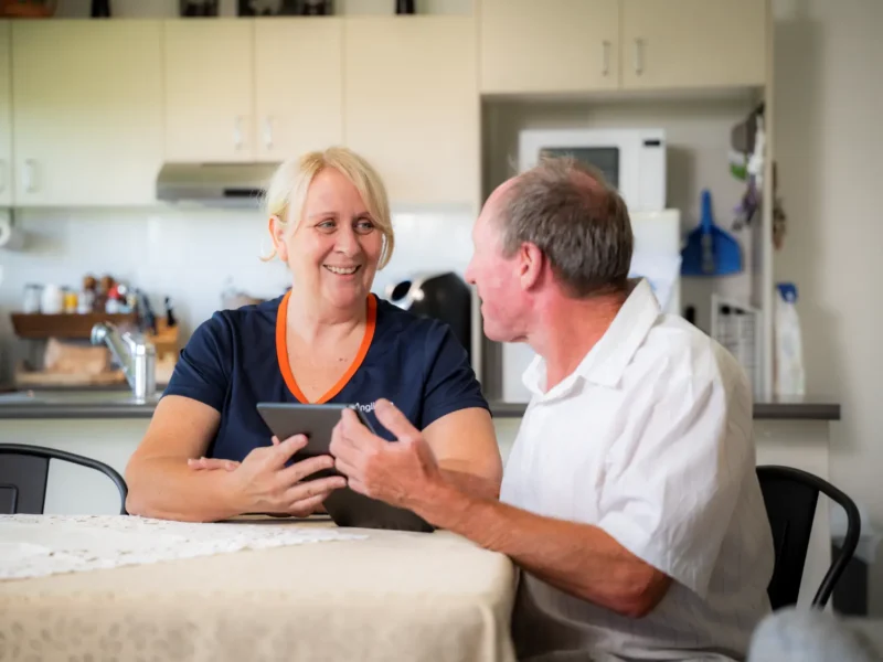 Anglicare staff helping client with paperwork.