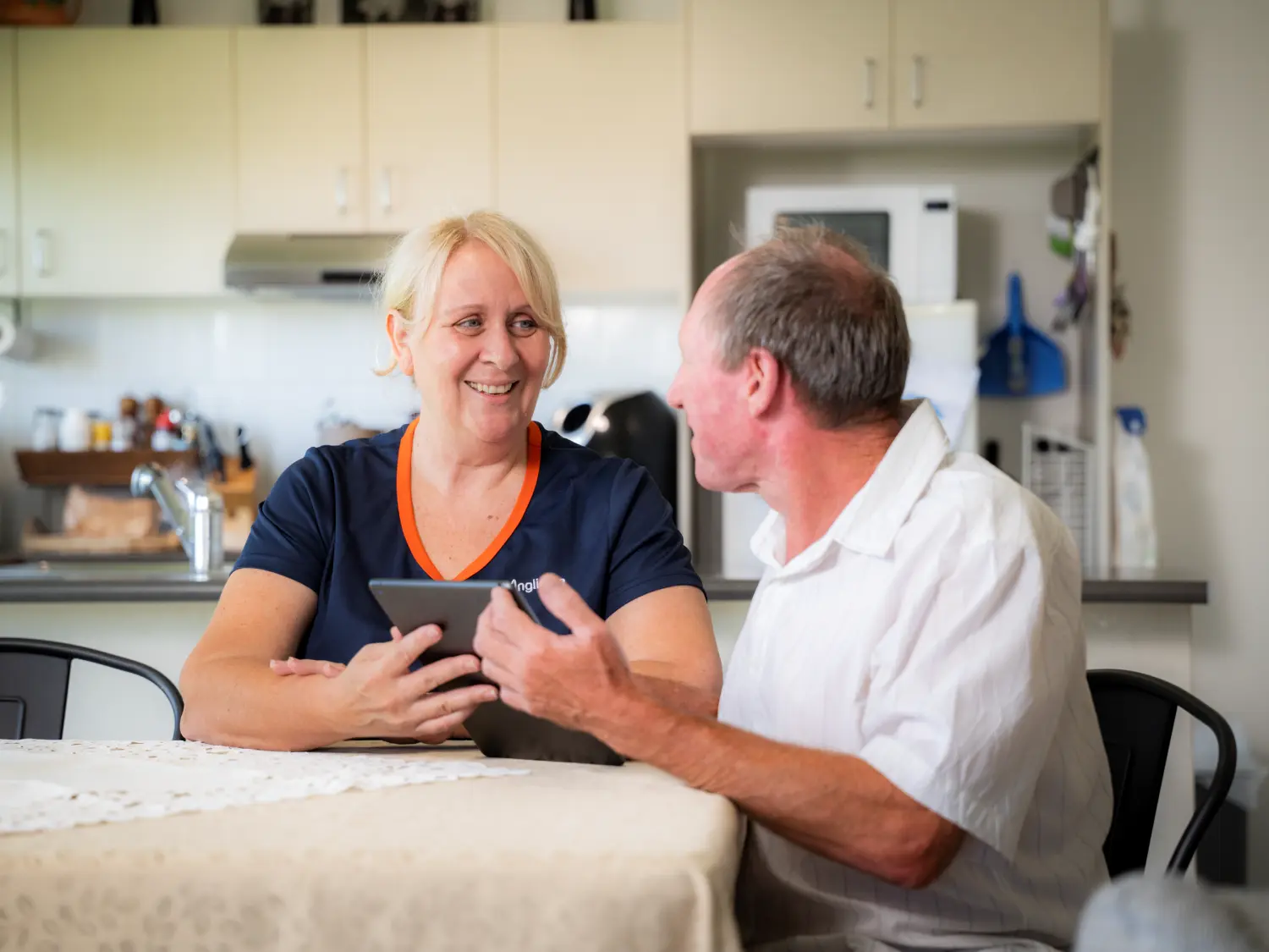 Anglicare staff helping client with paperwork.
