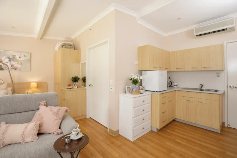 Light filled bedroom with kitchenette at Symes Thorpe residential aged care home