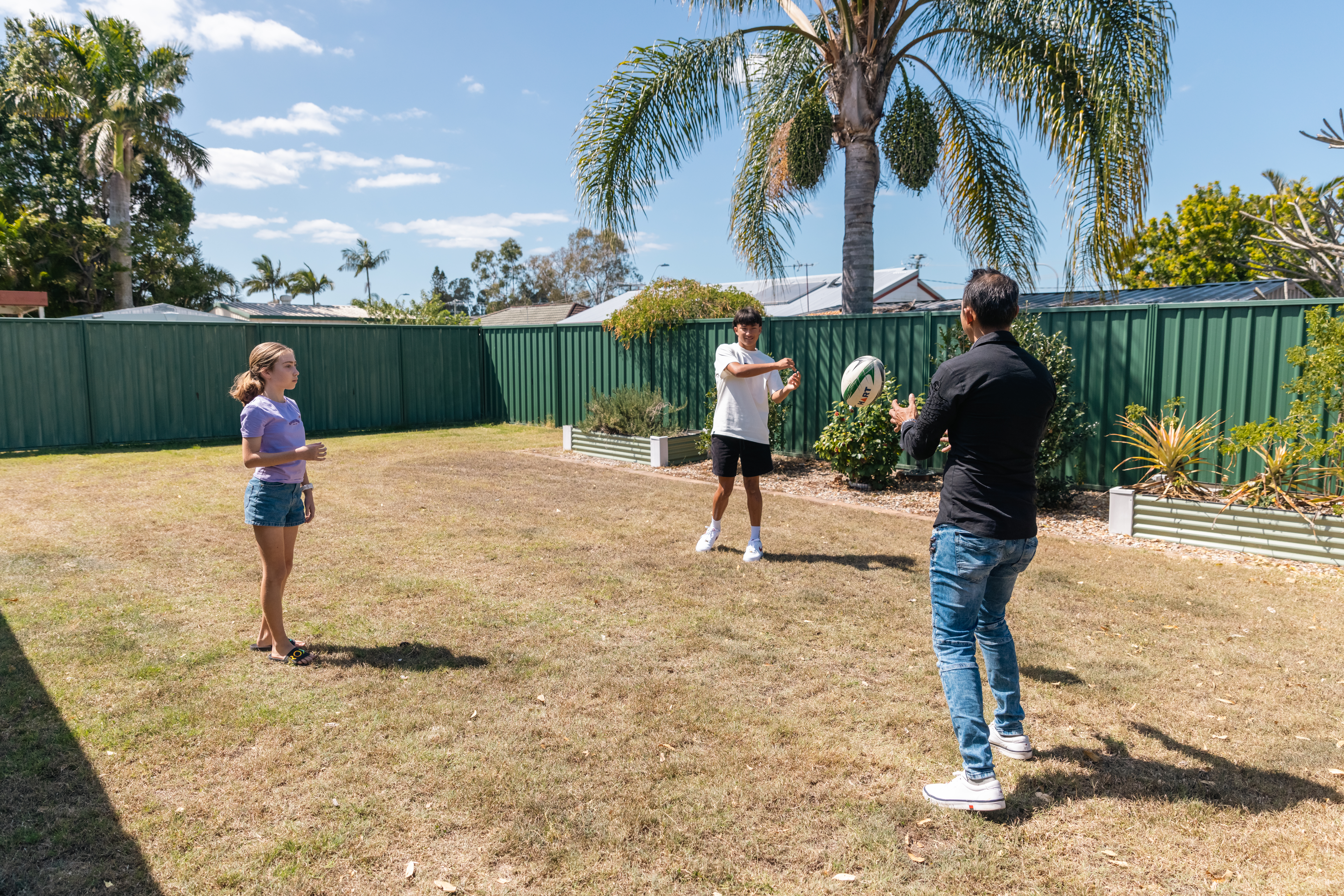 Bonding with your child: family playing football in backyard