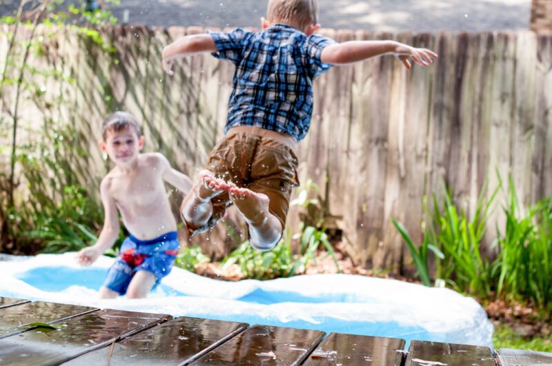 Two young foster children bouncing on a trampoline.