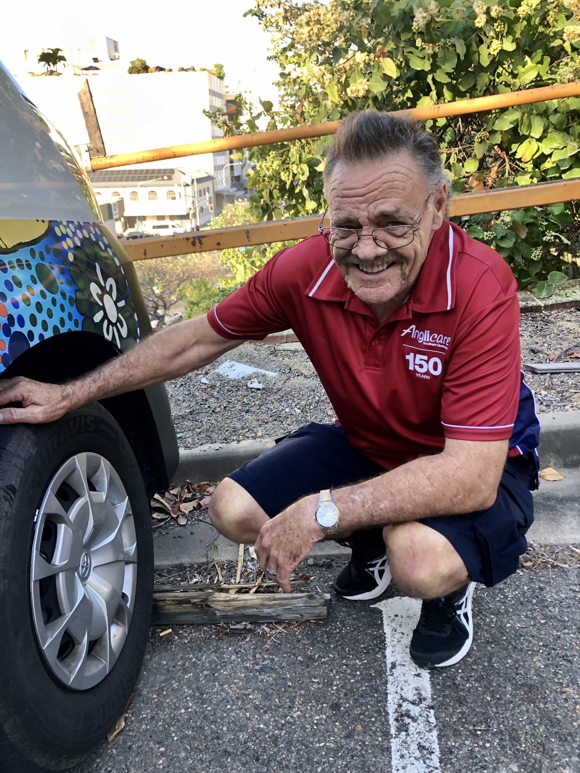 Anglicare support worker, Rob Main, fixing a clients tyre