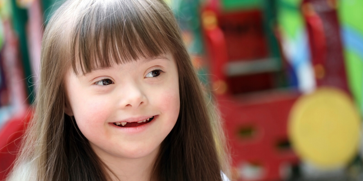 Trish and Graham's story.
Young girl smiling with disability.