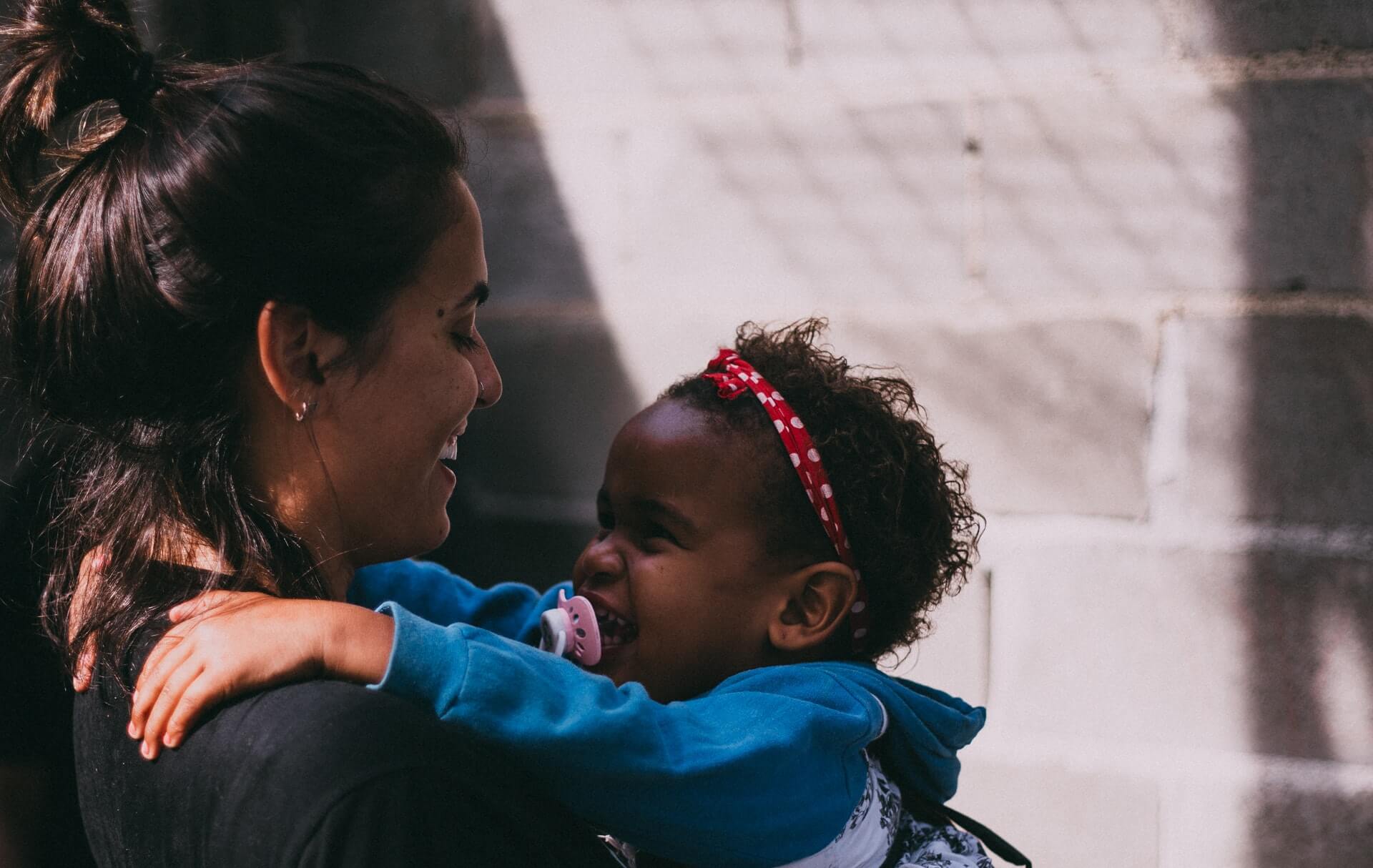What is fostering and foster care? Women and young girl showing affectionate care