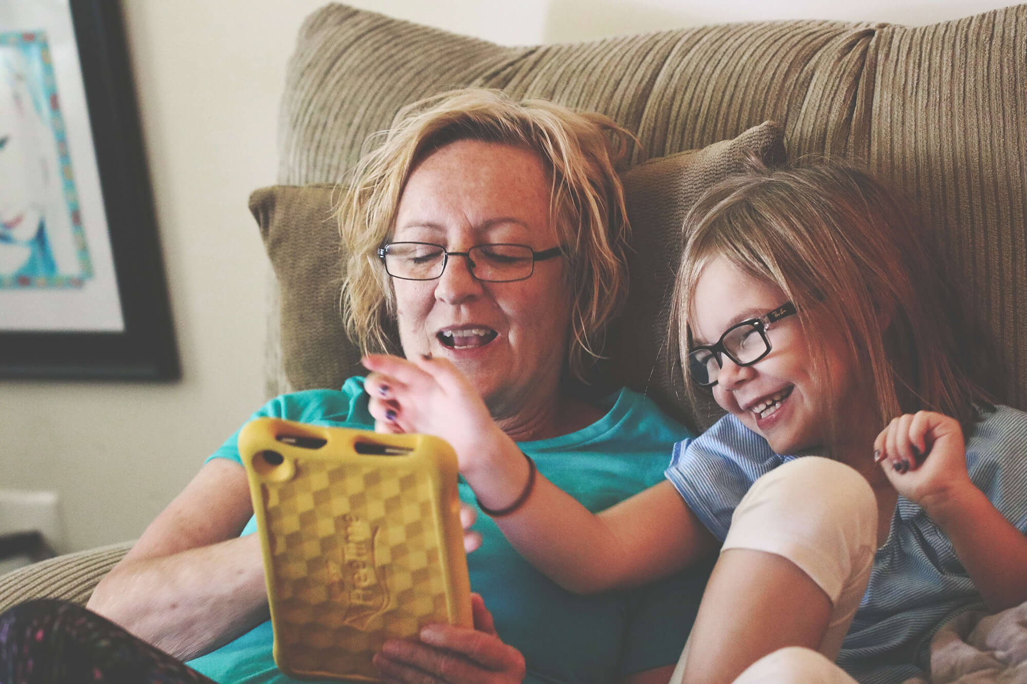 Becoming a Foster Carer: Adult woman playing with girl on couch