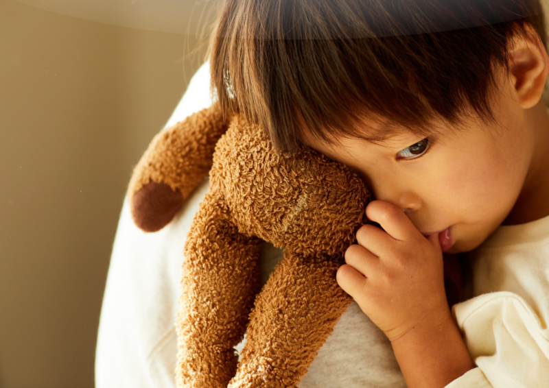 Foster carer soothing a young child in distress.